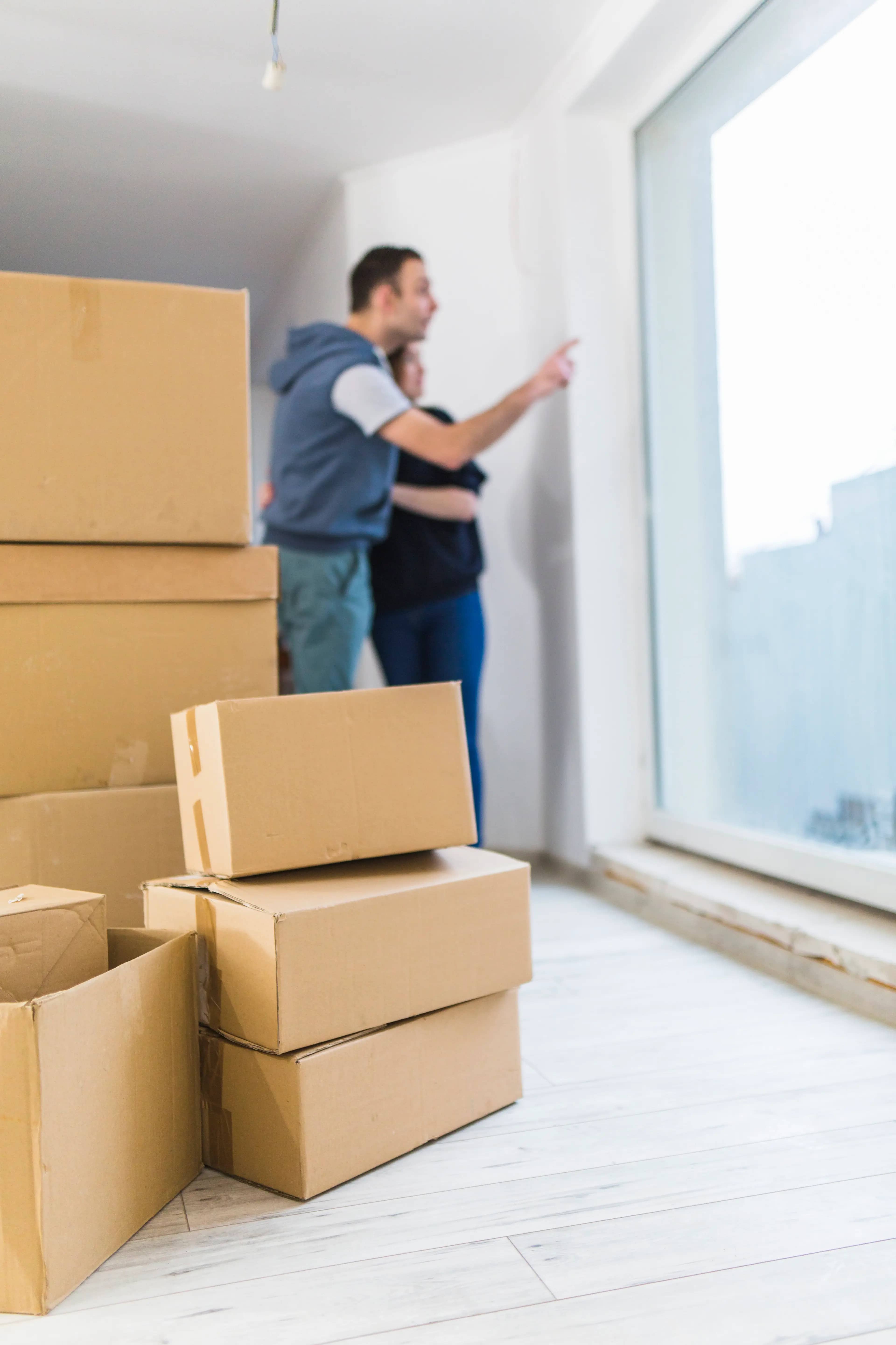 carton boxes near blurred couple